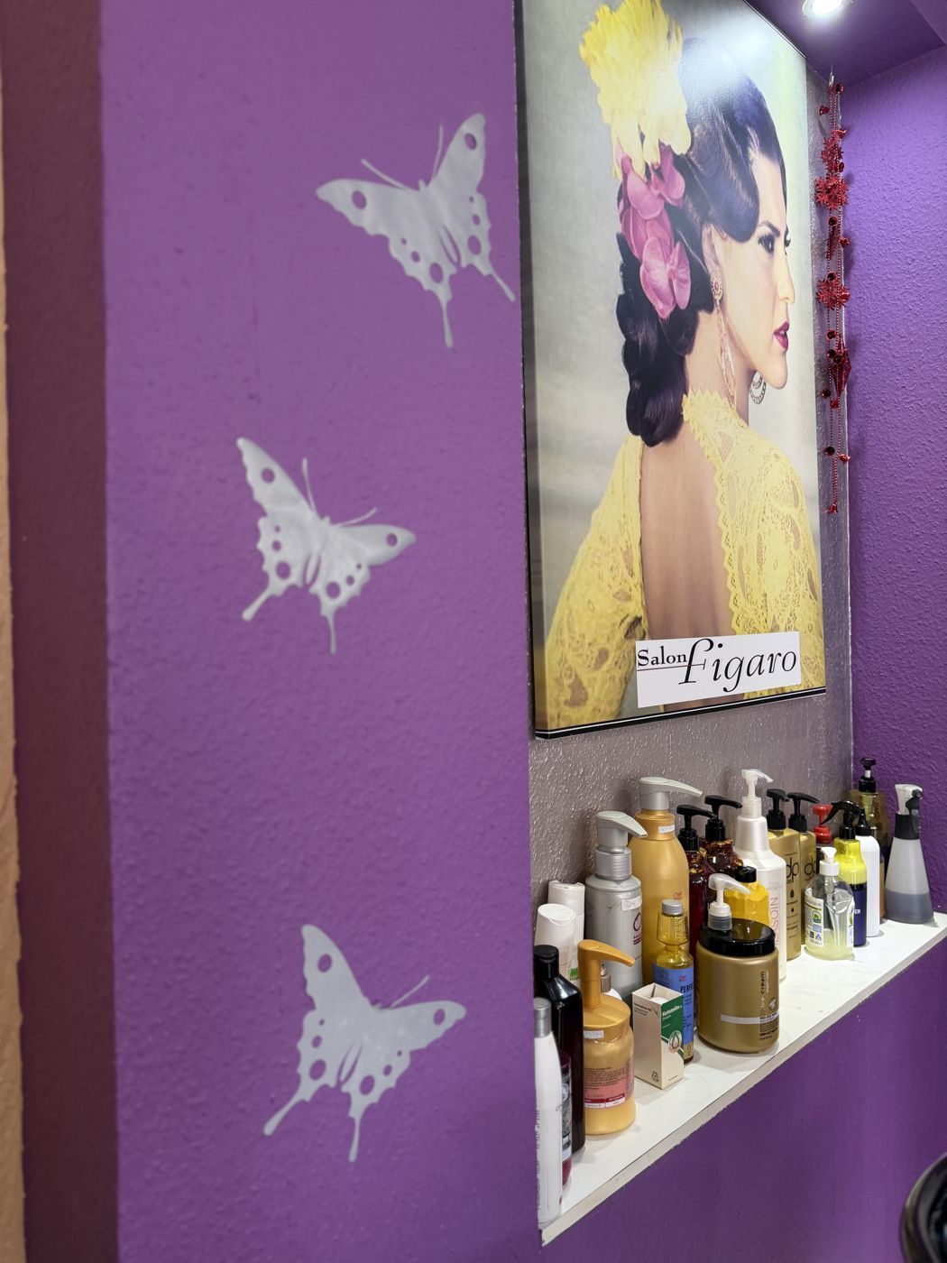 Lila Wand mit Schmetterlingen und Pflegeprodukten am Waschplatz